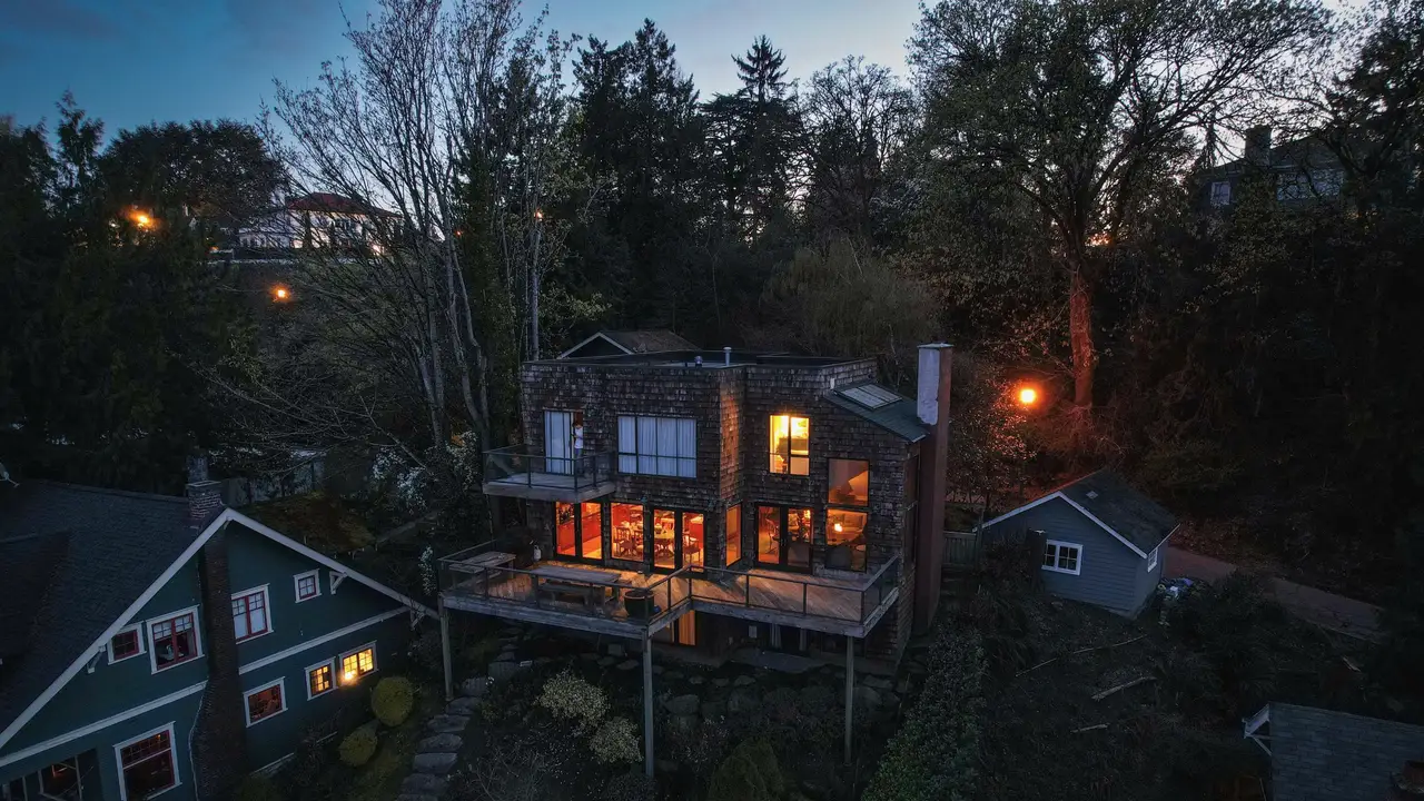Wooded South Sound neighbourhood at dusk with lit windows