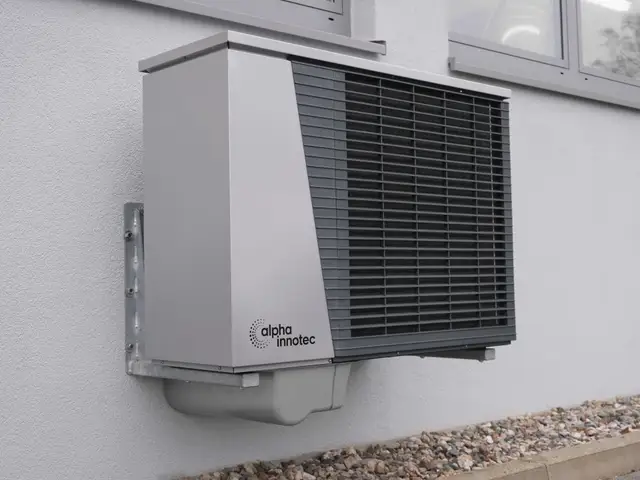 Wall-bracketed outdoor unit on a pale render wall
