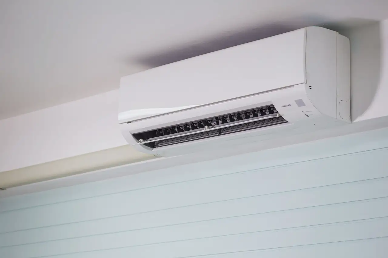 Close view of a white wall-mounted indoor unit near the ceiling