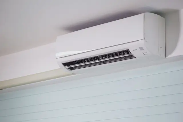 Close view of a white wall-mounted indoor unit near the ceiling